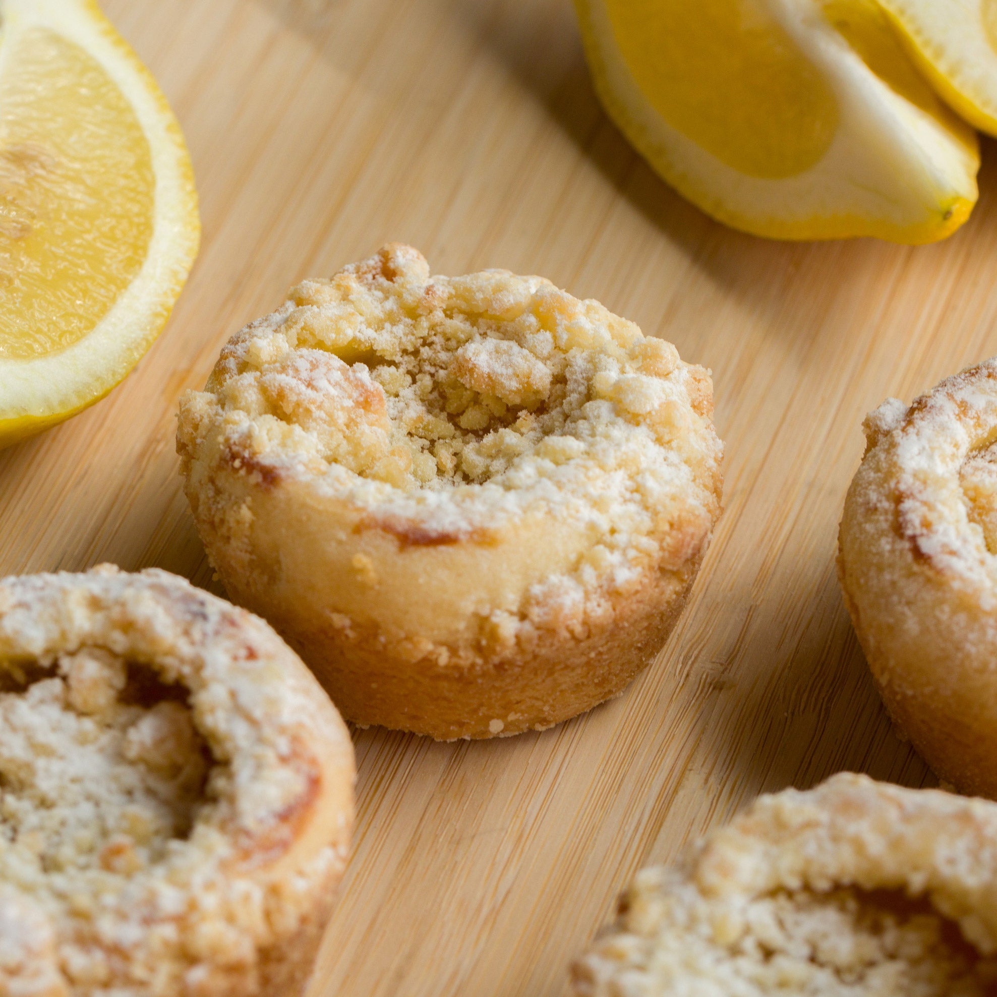 Lemon muffins on a wooden board with lemons in the background